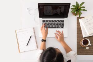 Escritorio con portátil, agenda y café para planificar la gestión de un negocio