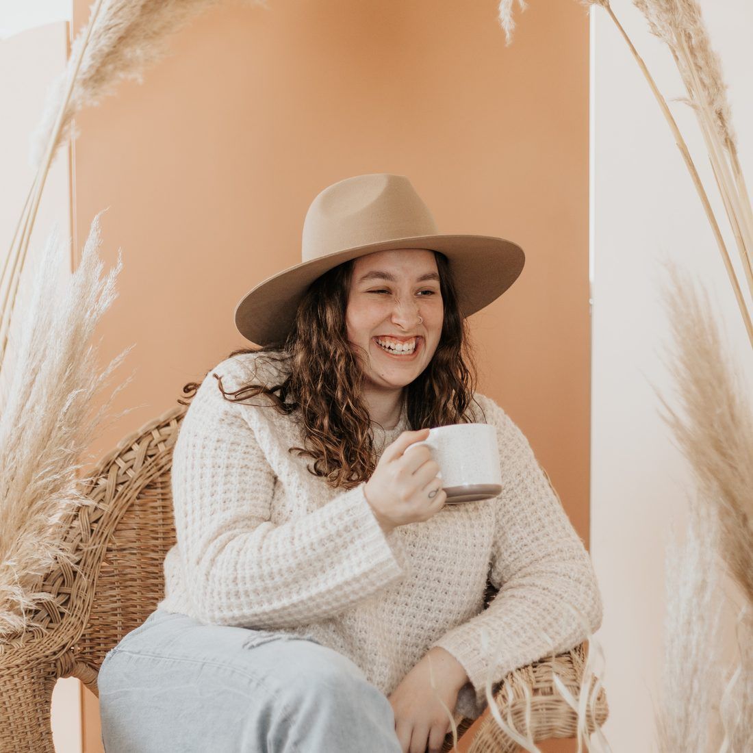 Mujer emprendedora sonriendo con un café, en un momento de cambio personal y profesional